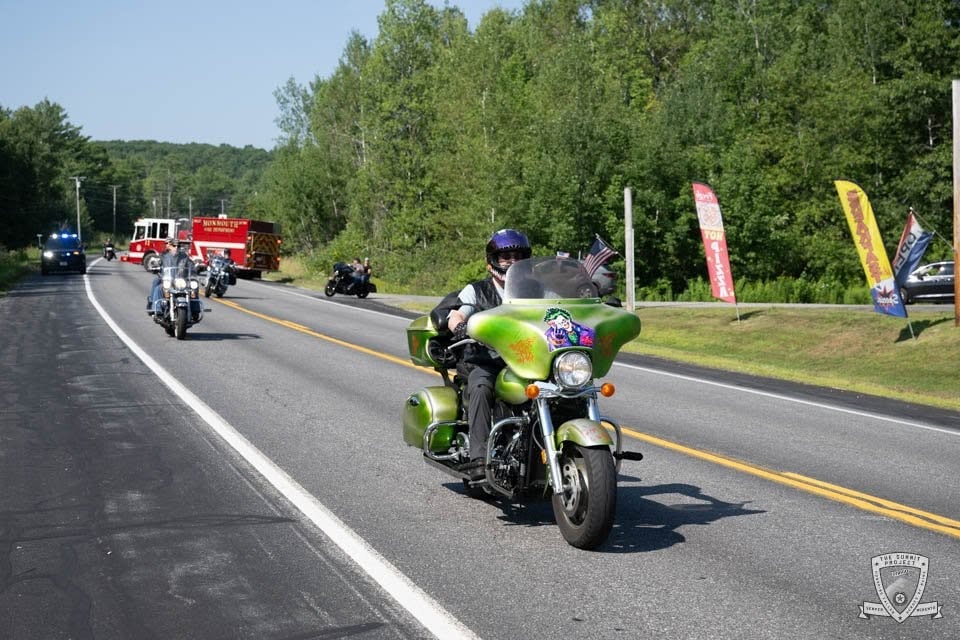 A custom green bike leads the procession with the Monmouth FD close behind.