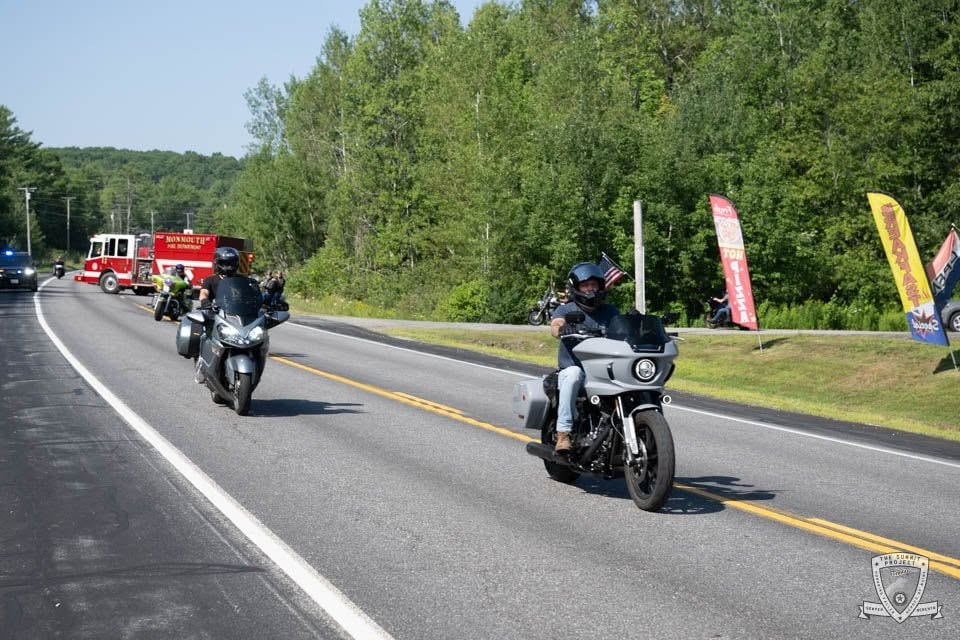 Two riders lead the procession with the Monmouth Fire Department truck close behind.