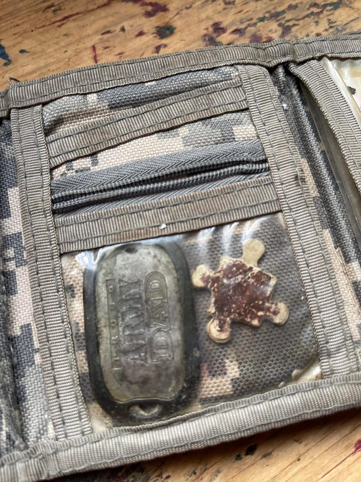 Jeff's ACU camouflage wallet open to reveal an Army Dad tag and Andrew's puzzle piece tucked inside